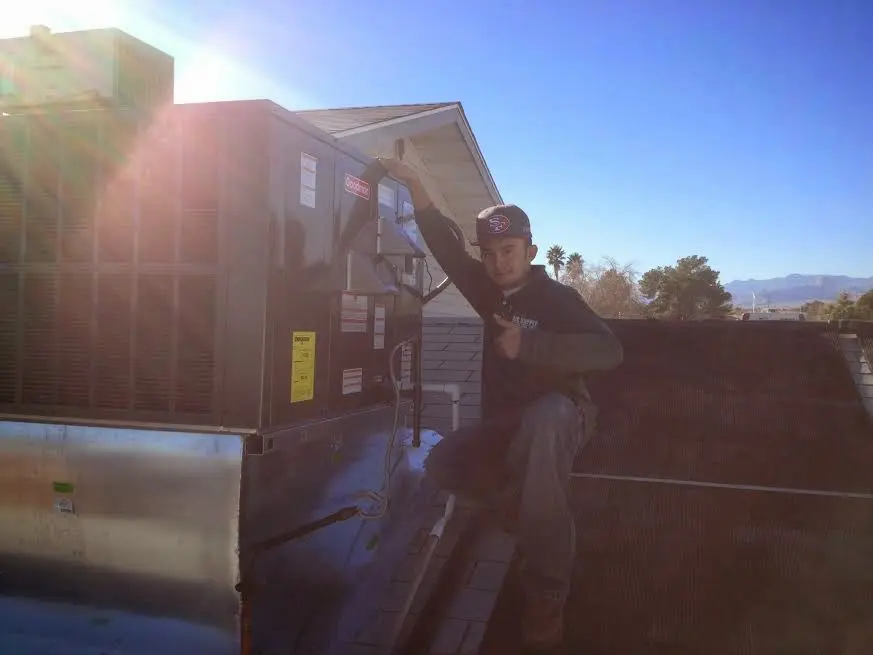 HVAC technician performing Boiler Repair on a rooftop unit in Groesbeck